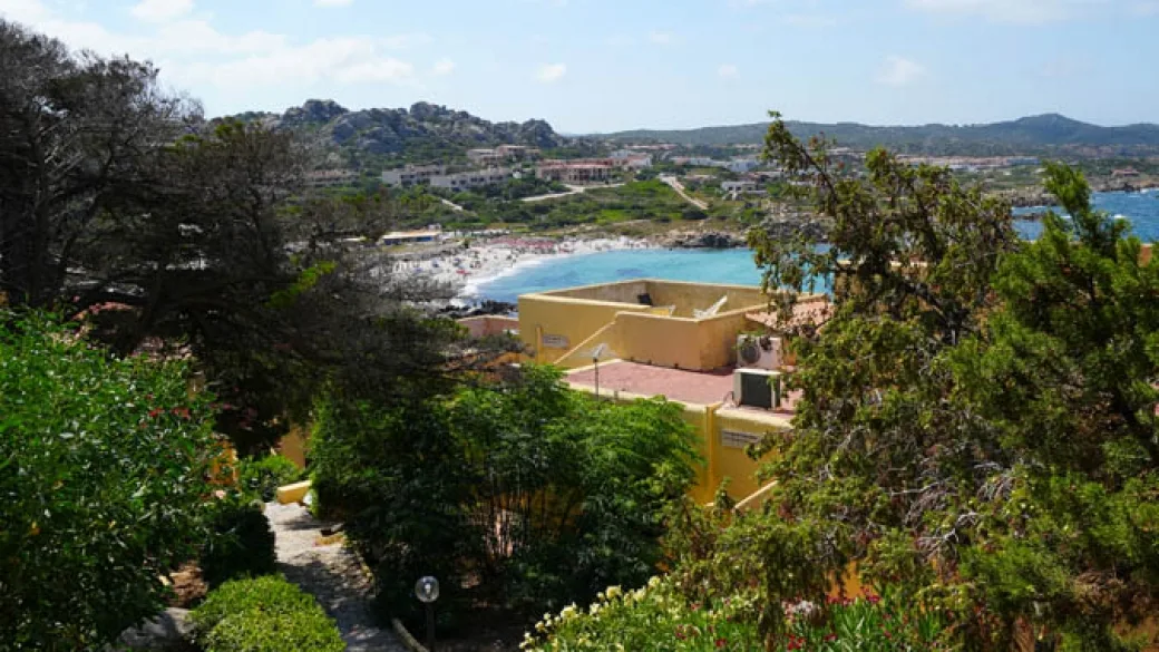 Vista sulla baia e spiaggia dal giardino del resort tra la vegetazione