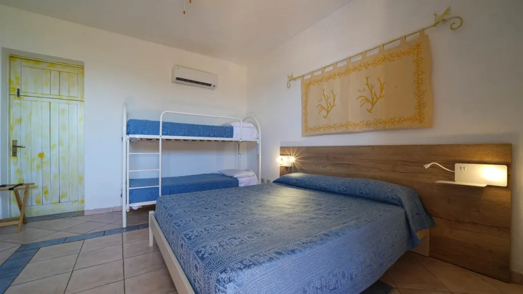 Camera con letto matrimoniale e letto a castello, arredi in stile sardo
