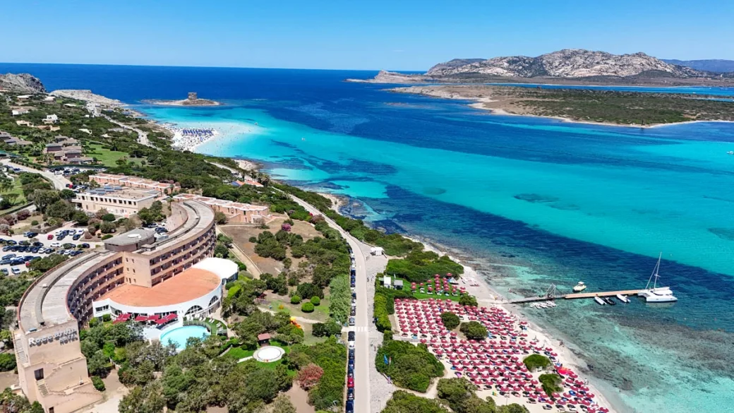 Veduta aerea dell'hotel e della costa con spiaggia attrezzata e mare cristallino