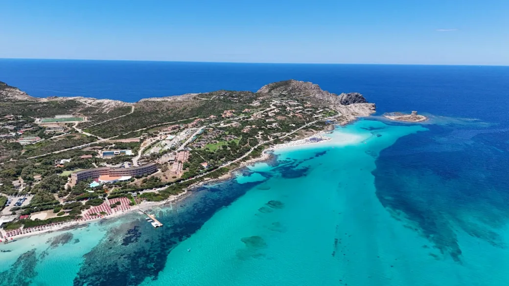 Vista panoramica della costa sarda con spiaggia, promontorio e mare turchese