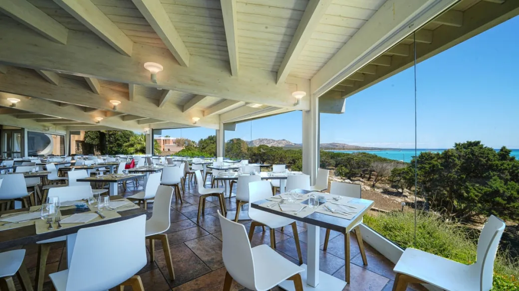 Ristorante con tavoli apparecchiati e vista panoramica sul mare