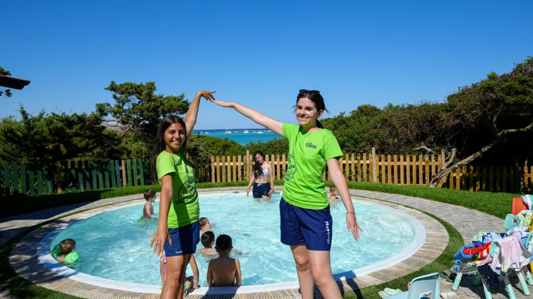 Animatrici e bambini presso la piscina per bambini con vista mare