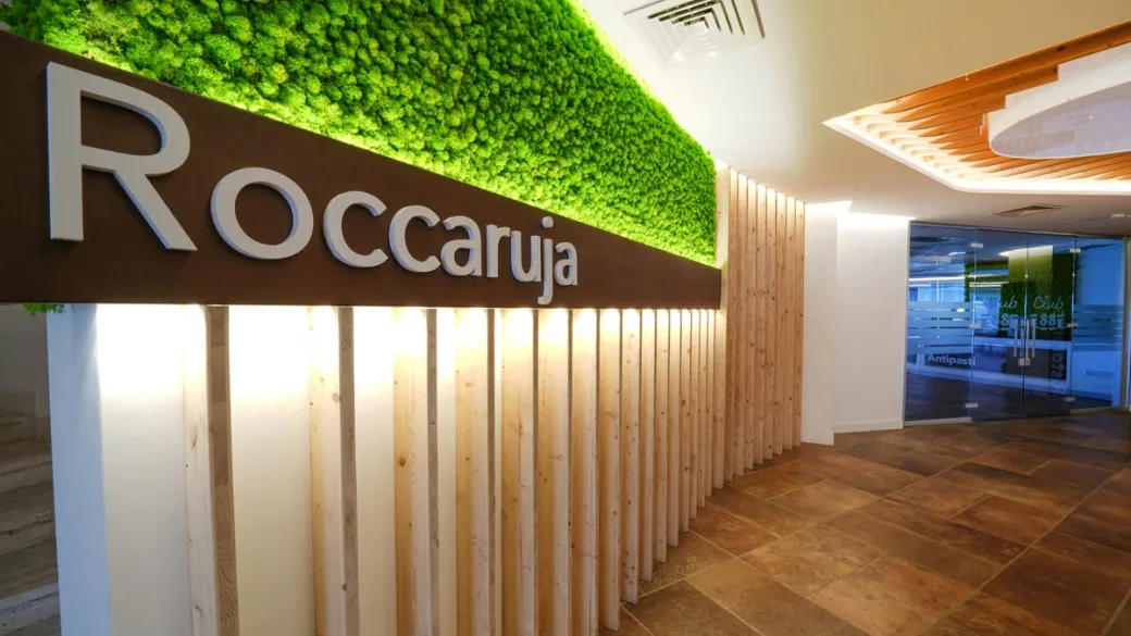 Ingresso con insegna Roccaruja e parete verde decorativa