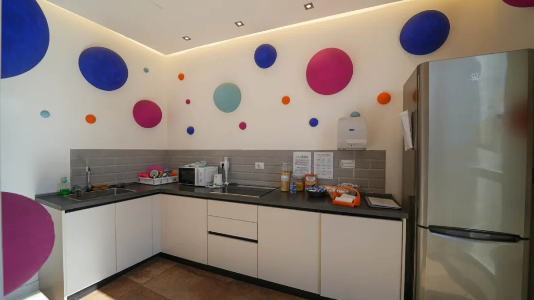 Cucina del miniclub con pareti decorate a pois e frigorifero