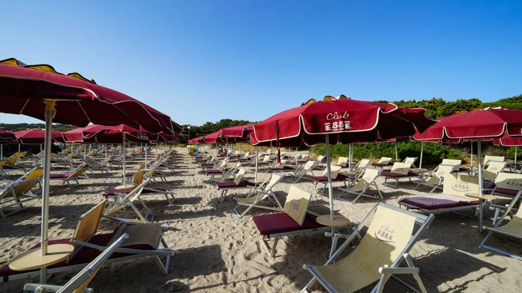 Spiaggia attrezzata con lettini e ombrelloni rossi Club Esse