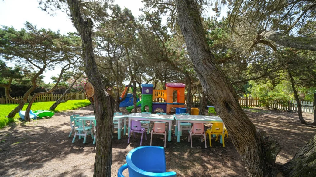 Area giochi all'aperto per bambini all'ombra degli alberi