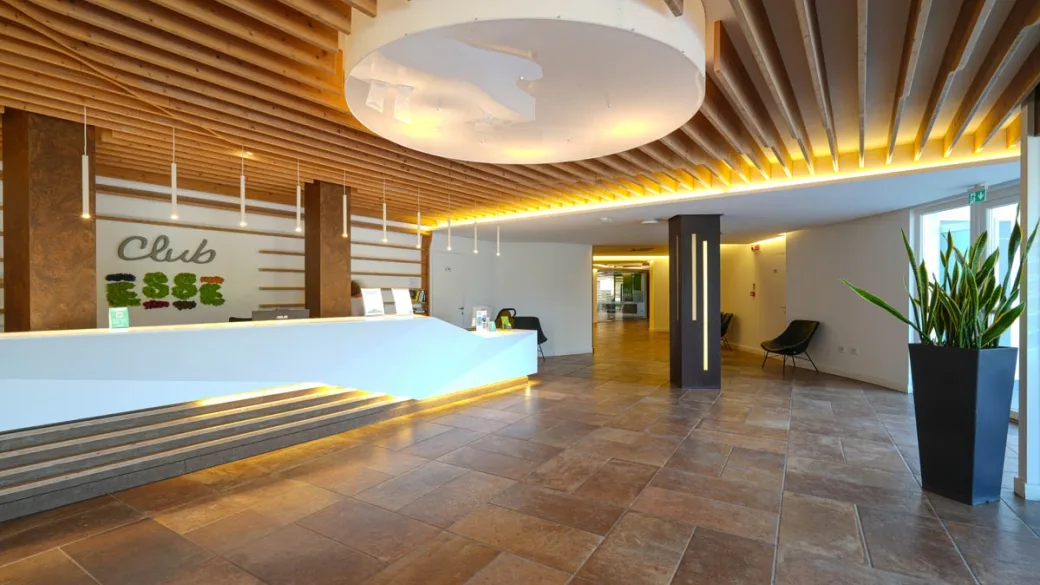 Reception del Club Esse con soffitto in legno e arredi moderni