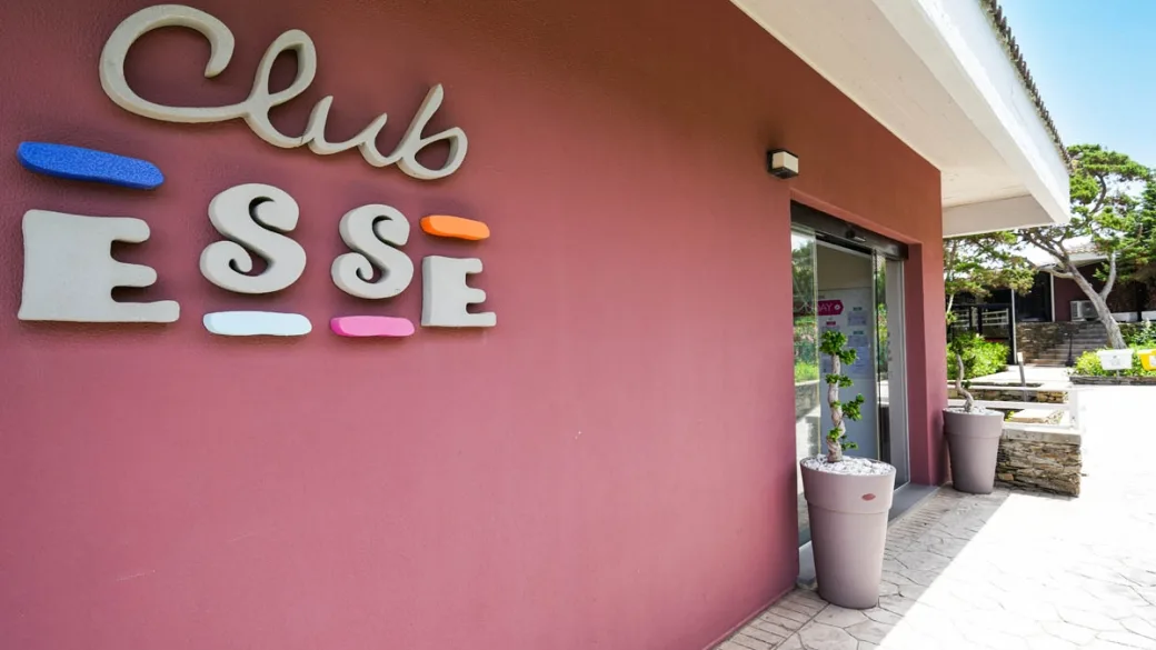 Ingresso del Club Esse con insegna colorata su parete rosa
