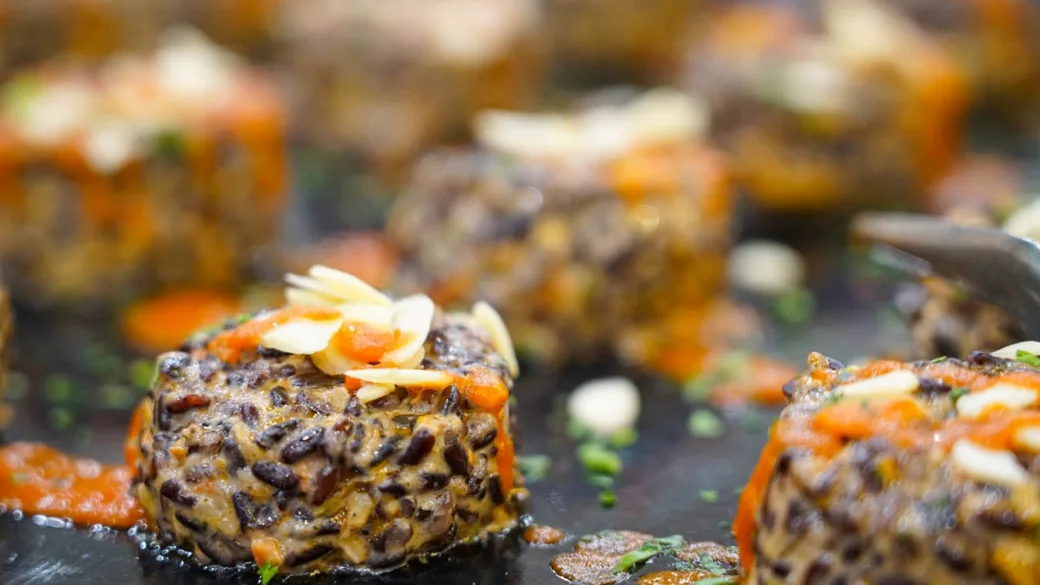Primo piano di polpette di riso venere con mandorle e salsa