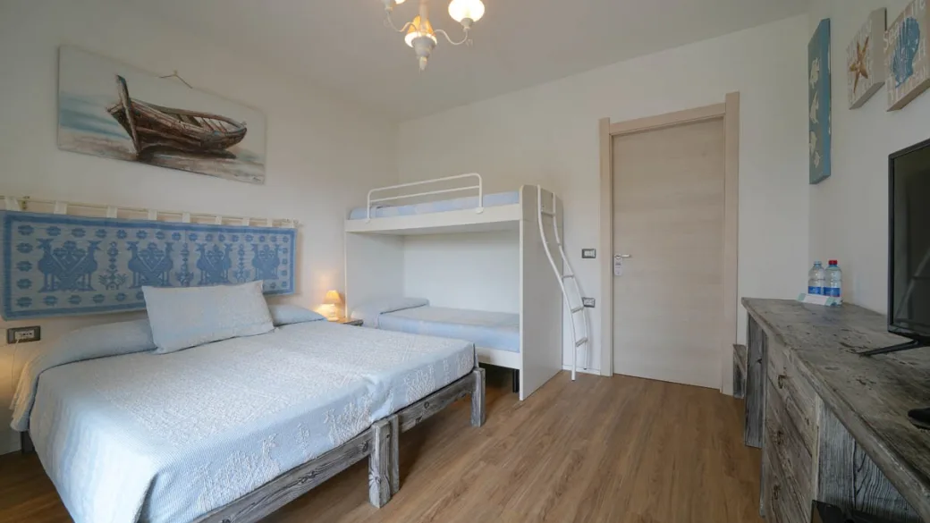 Camera con letto matrimoniale, letto a castello e arredi in legno
