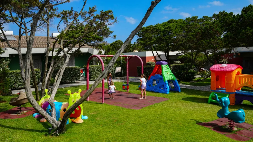 Area giochi all'aperto per bambini con altalene e scivoli colorati