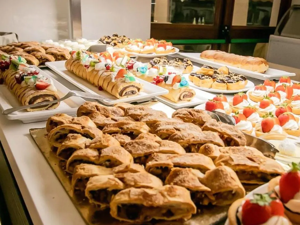 Buffet di dolci con torte, crostate di fragole e strudel su vassoi
