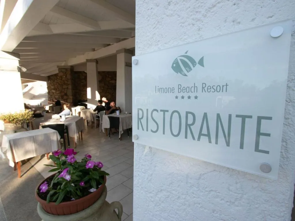 Insegna del ristorante Limone Beach Resort con tavoli apparecchiati sullo sfondo