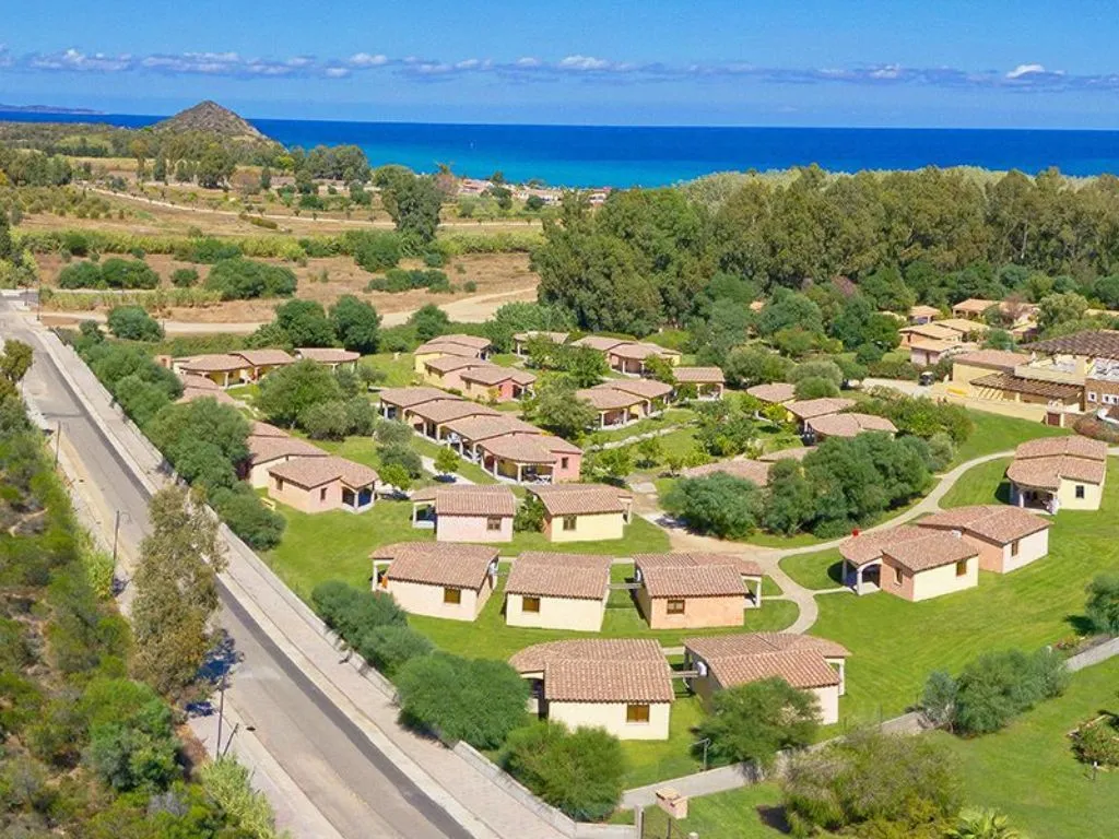 Veduta aerea delle ville con tetti in tegole immerse nel verde con il mare sullo sfondo