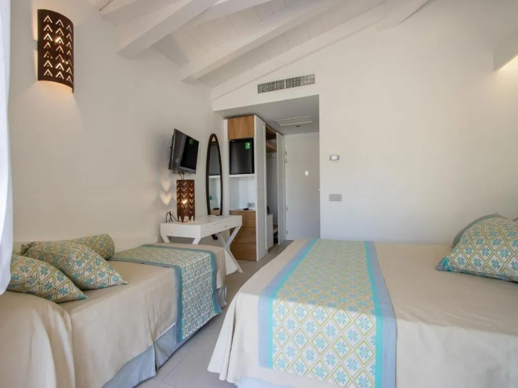 Camera con letto matrimoniale e singolo, testiera in legno decorata e specchio