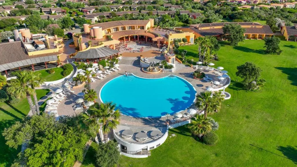 Veduta aerea della piscina circolare circondata da palme e prato verde