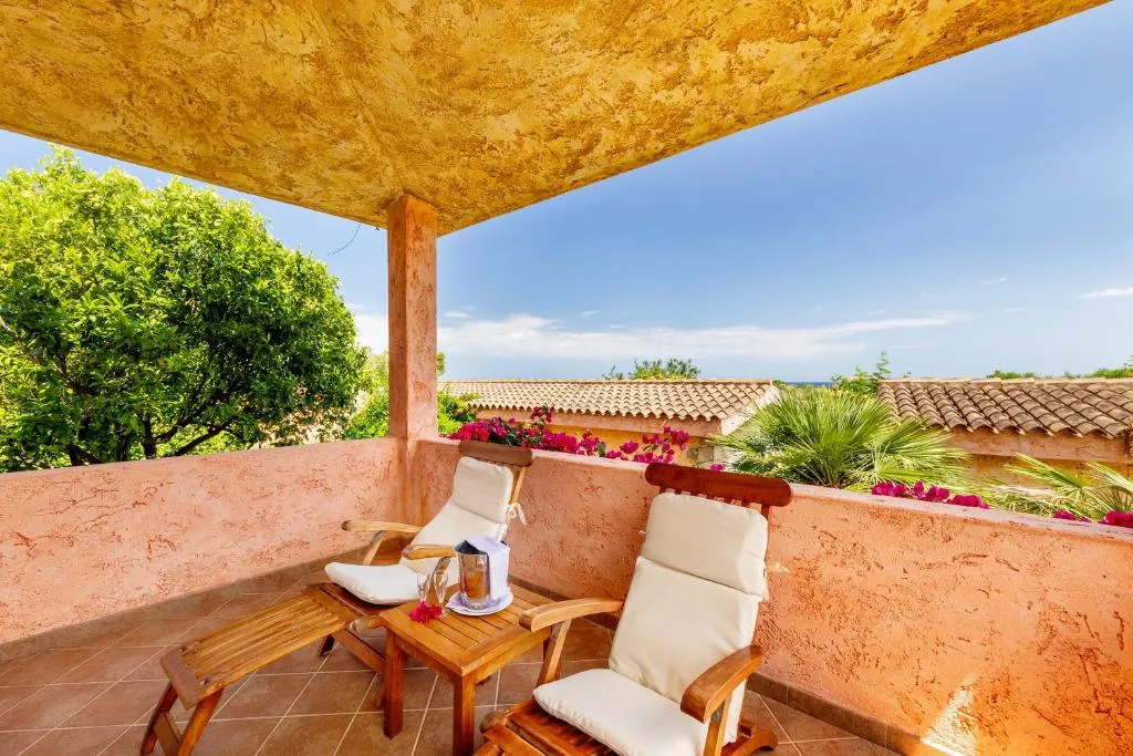 Terrazza privata con poltrone in legno e bouganville fiorita
