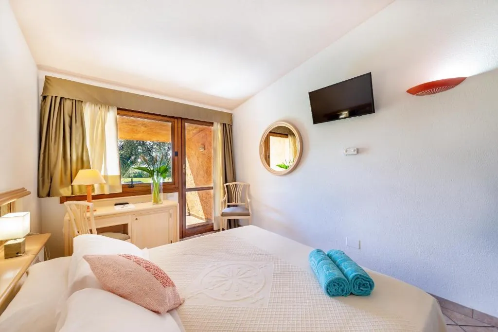 Camera matrimoniale luminosa con letto, TV a parete e finestra