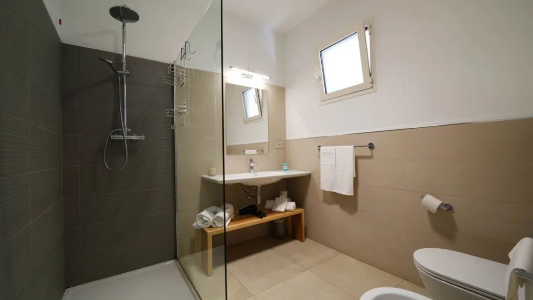 Bagno moderno con doccia in vetro e mobile lavabo