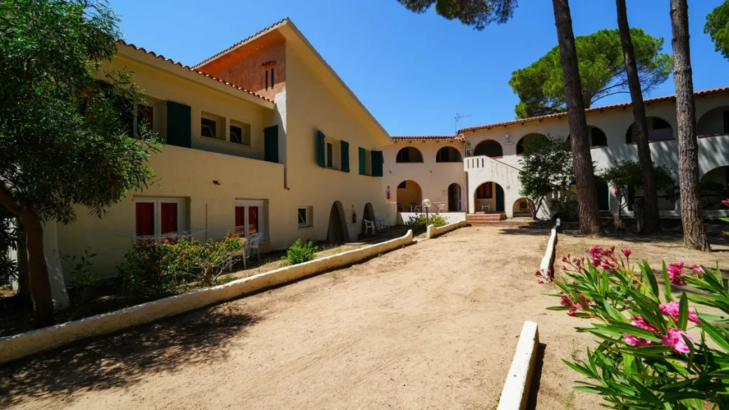Edificio in stile mediterraneo con archi e vialetto immerso nel verde