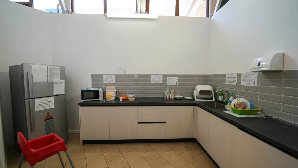 Cucina attrezzata con frigorifero, microonde e seggiolone per bambini