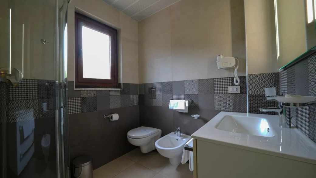 Bagno moderno con doccia, bidet, wc e lavabo con piastrelle decorative