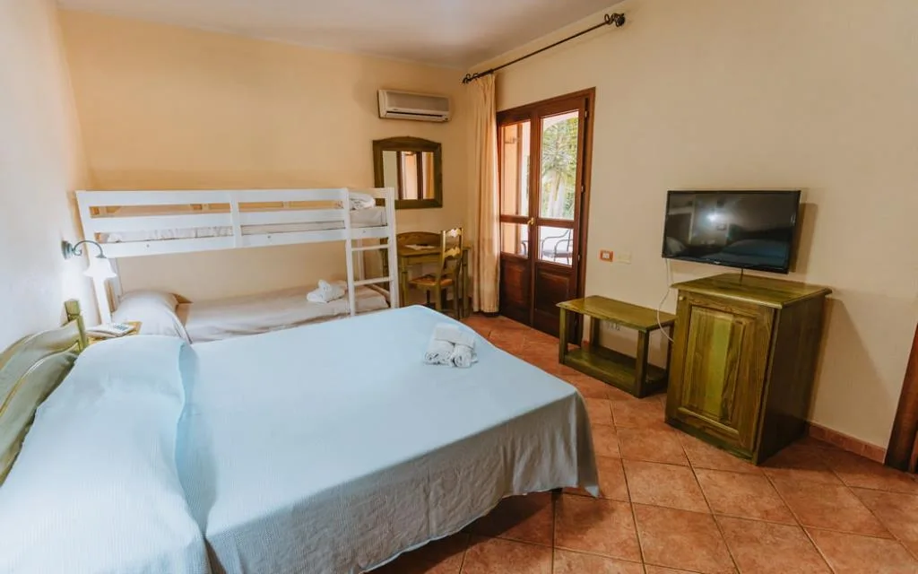 Camera familiare con letto matrimoniale, letto a castello, TV e mobili in legno