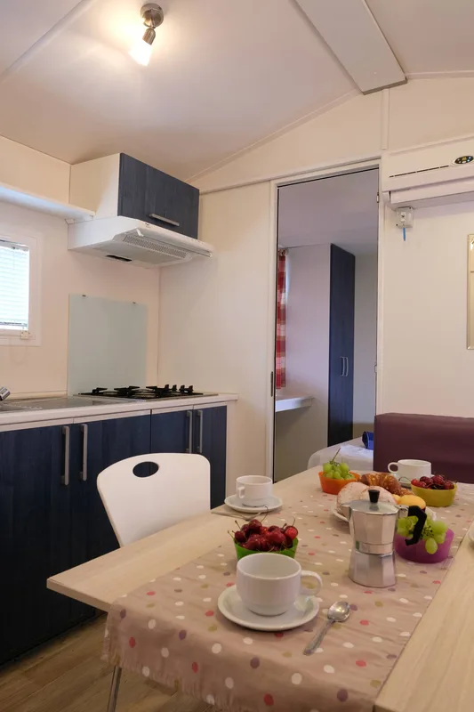 Cucina e zona pranzo di mobile home con tavola apparecchiata