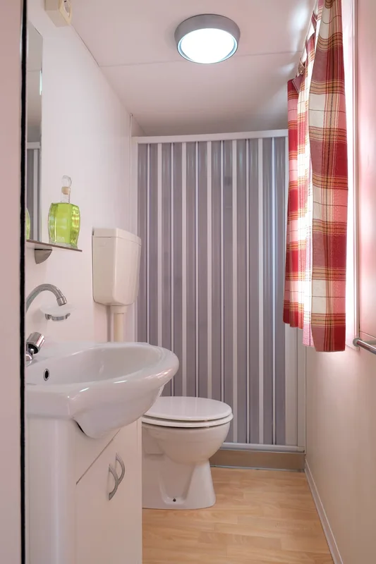 Bagno compatto con lavabo, wc e doccia con tenda