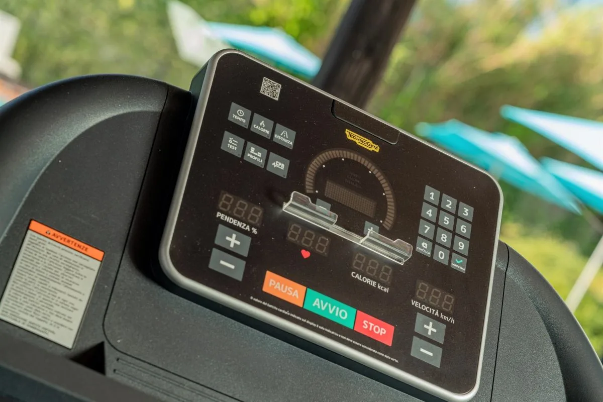 Dettaglio del display di un tapis roulant Technogym in area fitness all'aperto