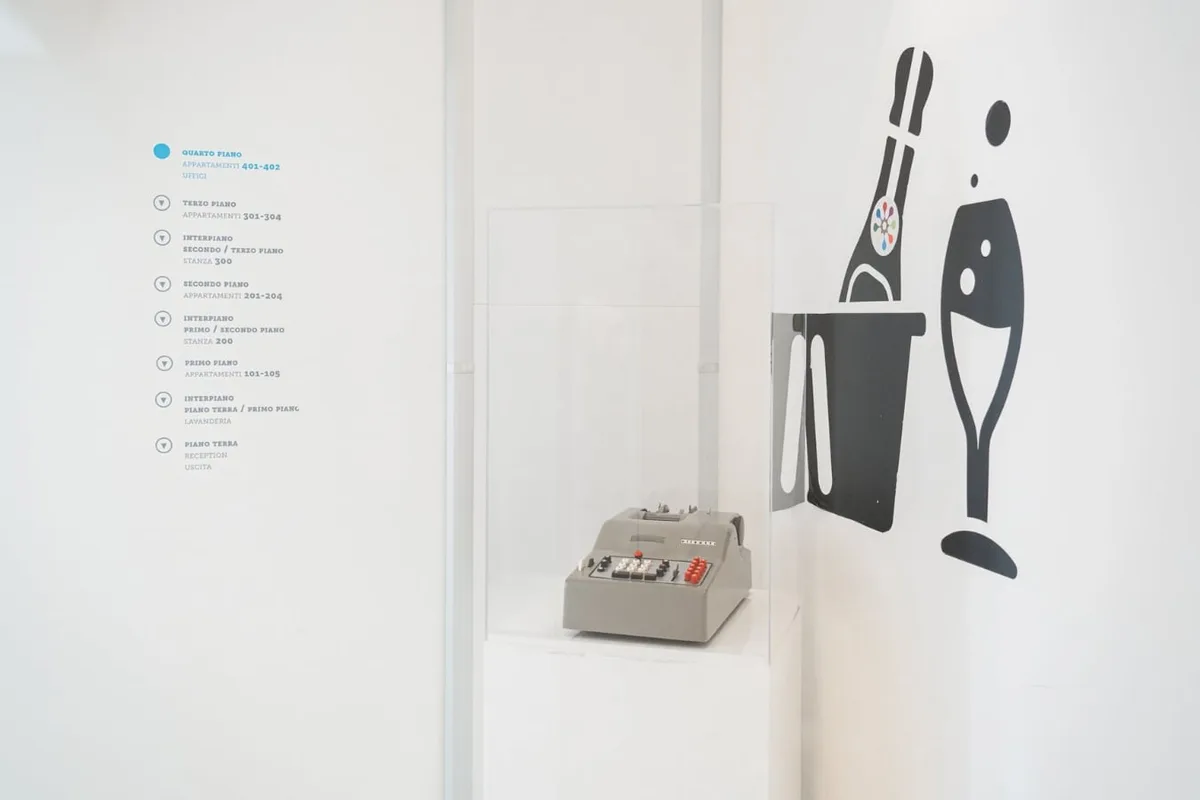 Esposizione con calcolatrice vintage in teca e grafiche a parete