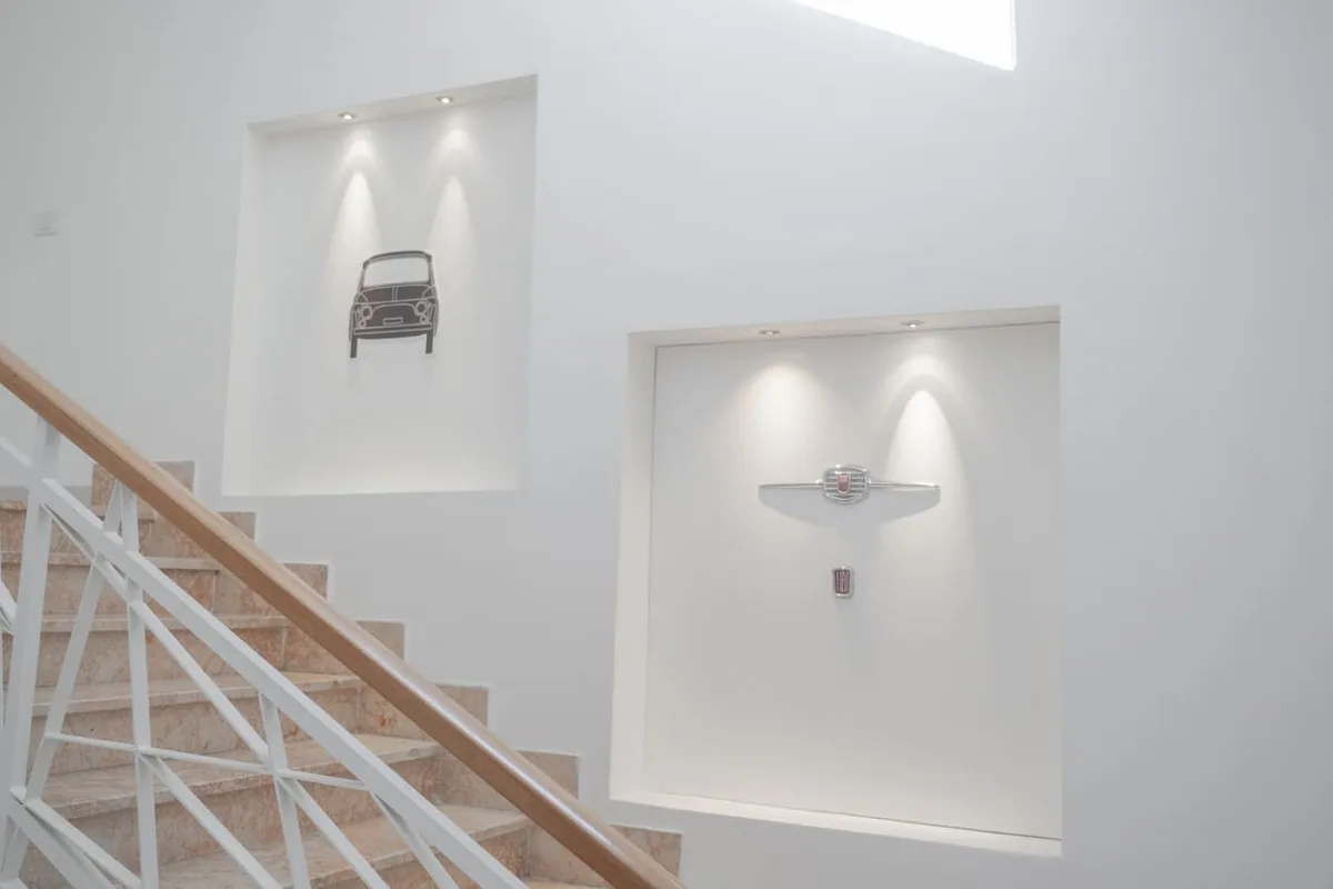 Scala interna con nicchie illuminate e decorazioni a tema automobilistico