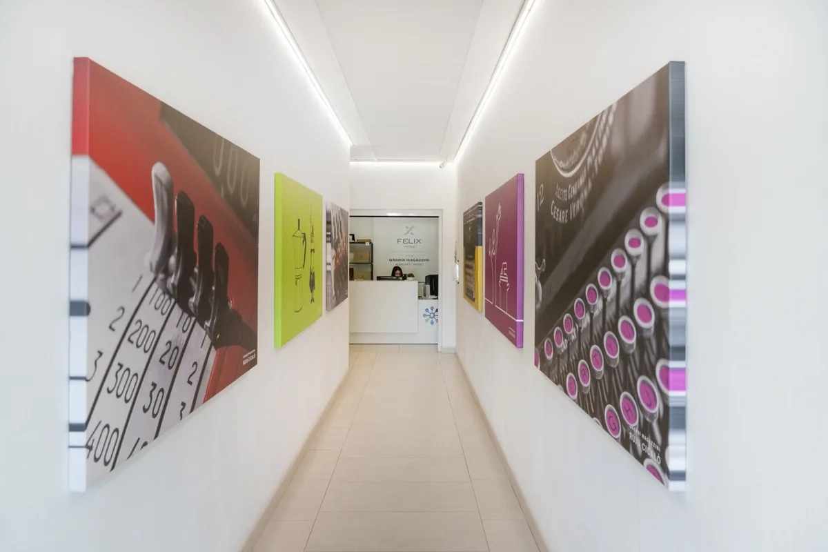 Corridoio con grandi pannelli fotografici colorati e reception sullo sfondo