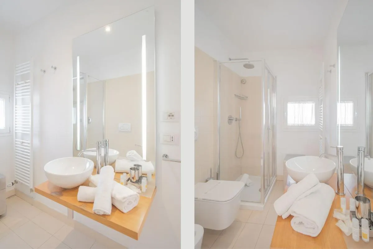 Bagno moderno bianco con doppio lavabo, specchio illuminato e doccia con box in vetro