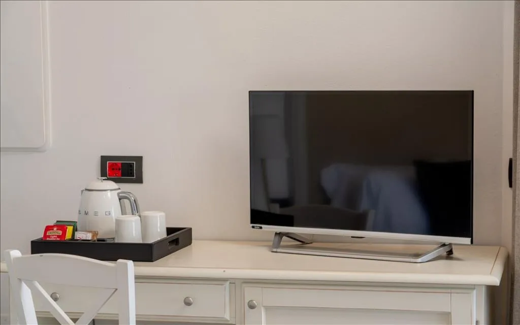 Dettaglio scrivania con TV, bollitore e set per tè e caffè