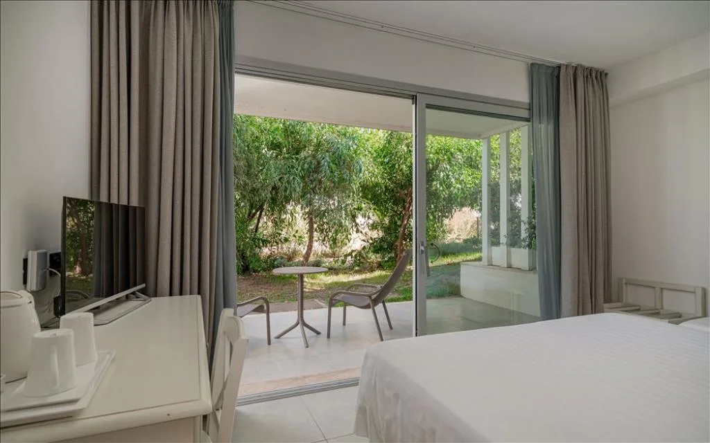 Camera con scrivania e ampia vetrata sul giardino con terrazza