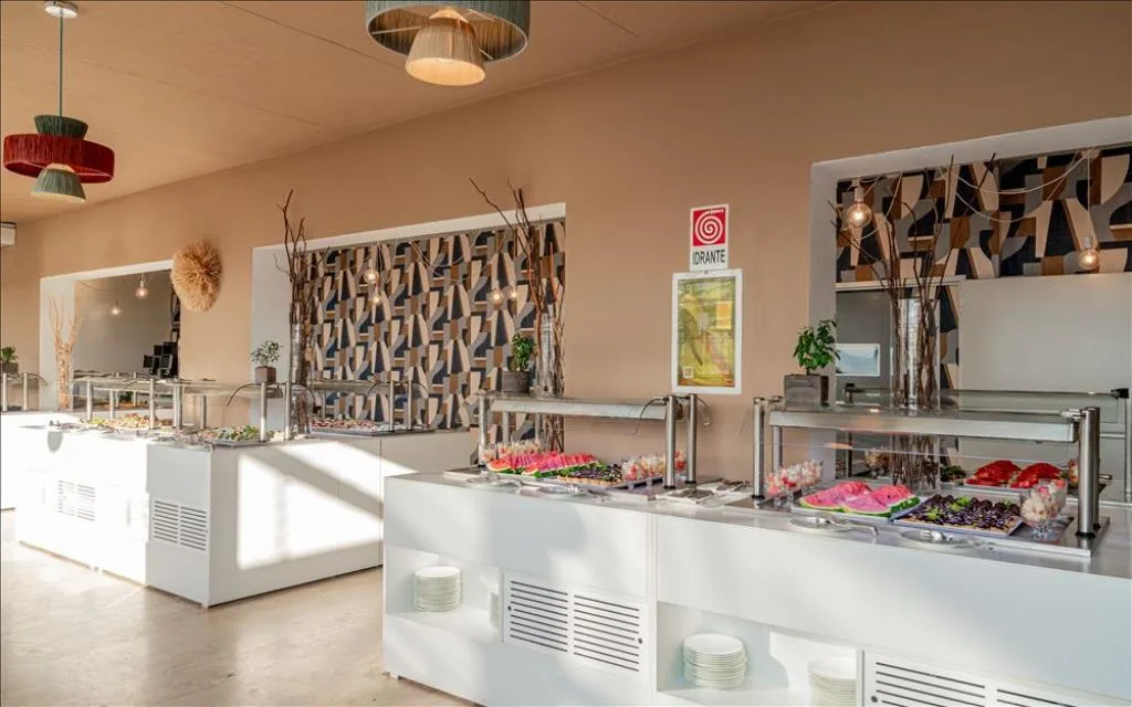 Buffet con frutta fresca e dolci sotto lampade decorative