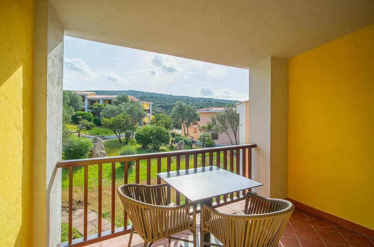 Balcone con tavolo e poltrone affacciato sulla collina e sul verde circostante