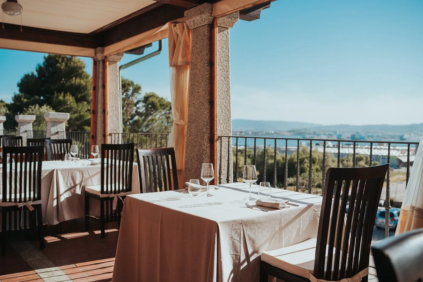 Terrazza del ristorante con tavoli apparecchiati e vista sul golfo