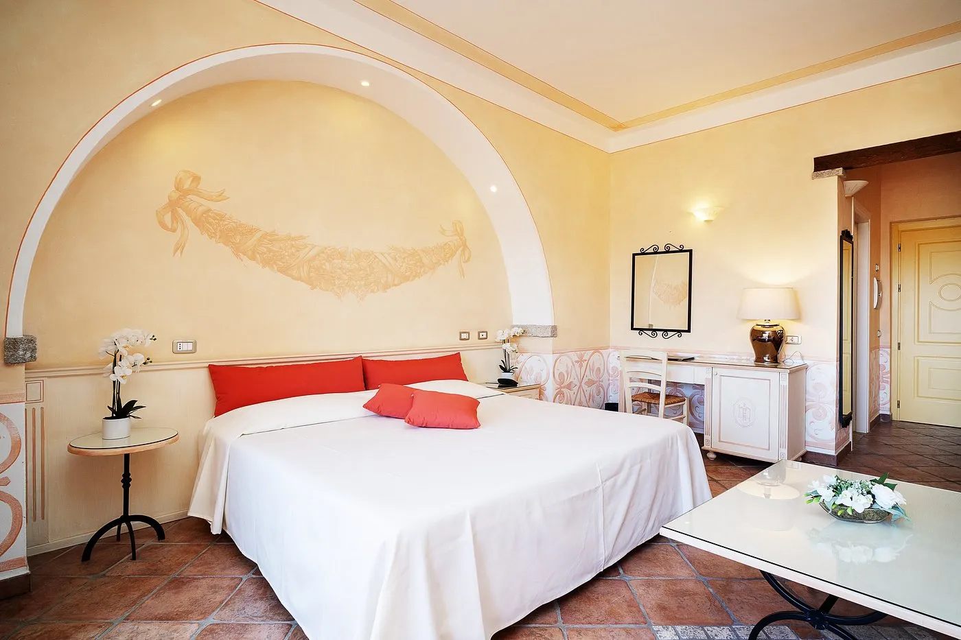 Camera con letto matrimoniale, parete decorata ad arco e scrivania