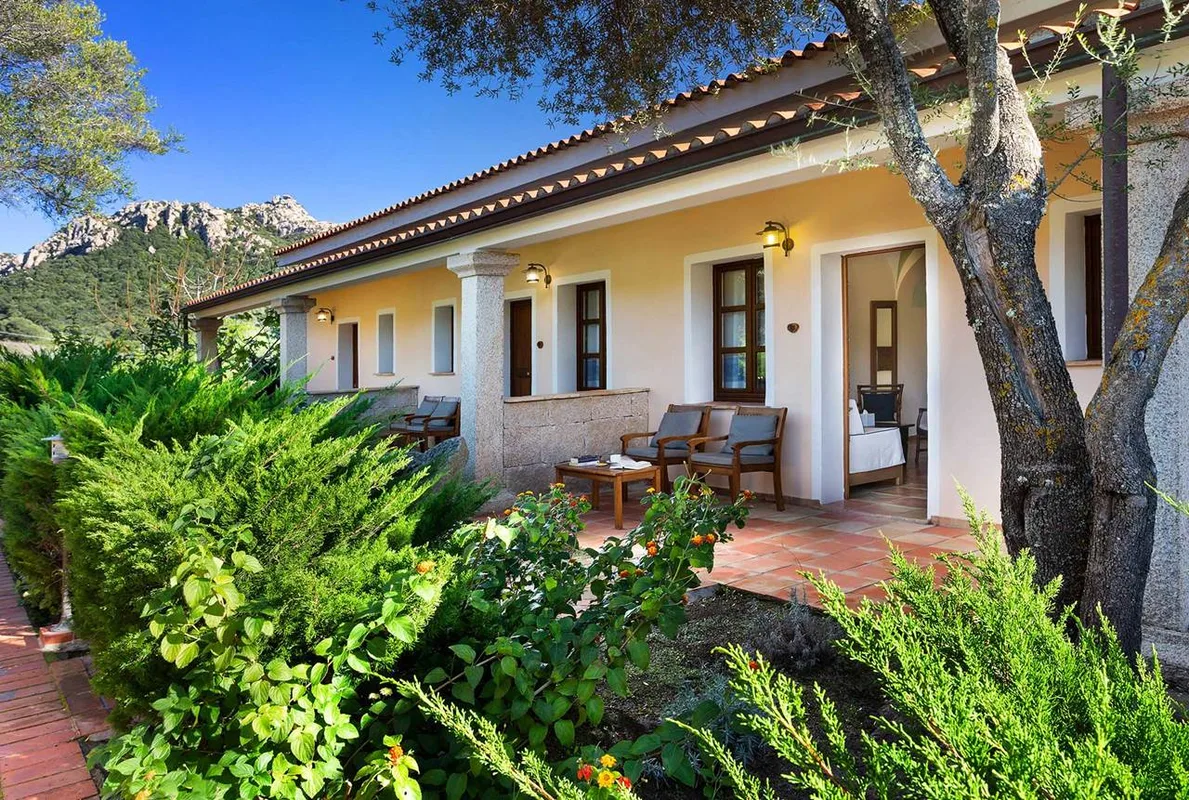 Veranda esterna con poltrone in legno e vista sulle montagne rocciose