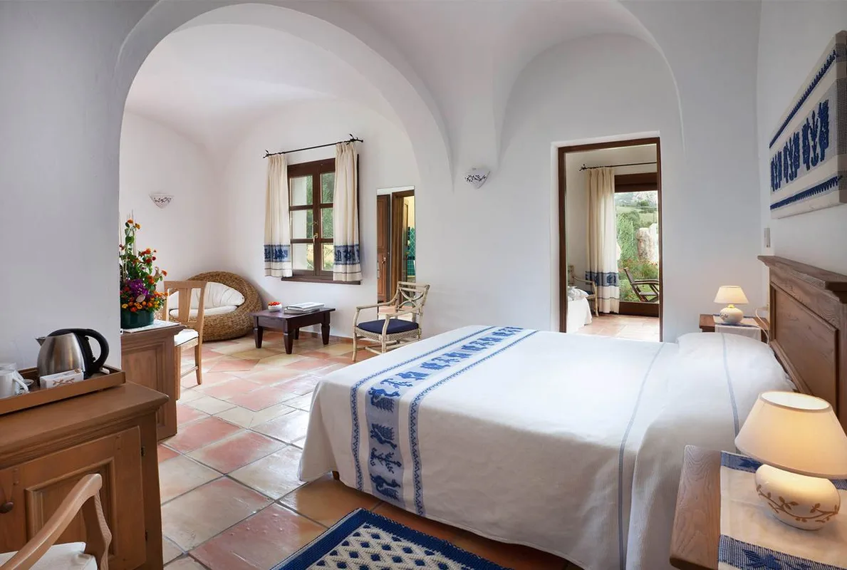 Suite in stile mediterraneo con soffitto a volta bianco e arredi tradizionali