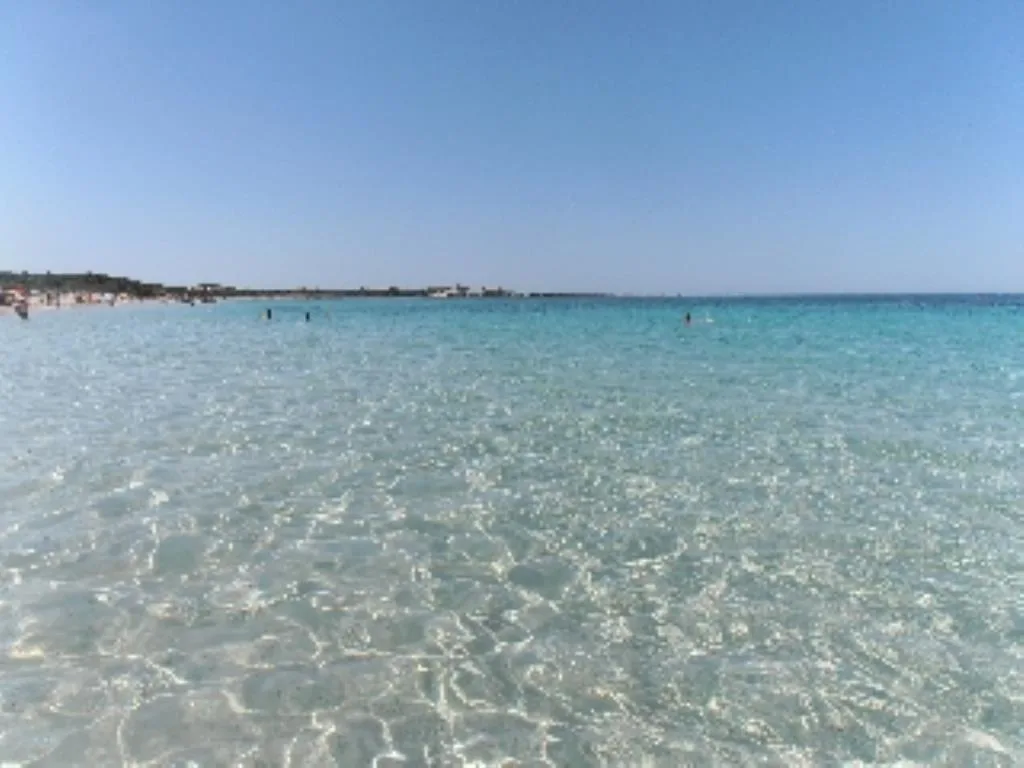 Acqua trasparente e poco profonda di una spiaggia sabbiosa