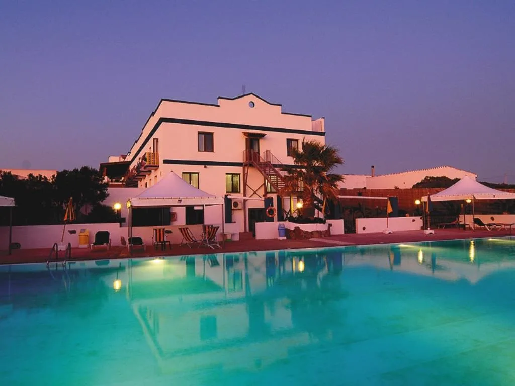 Edificio dell'hotel con piscina e gazebo illuminati al crepuscolo