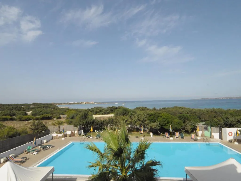 Vista dalla piscina sulla vegetazione e sul mare blu