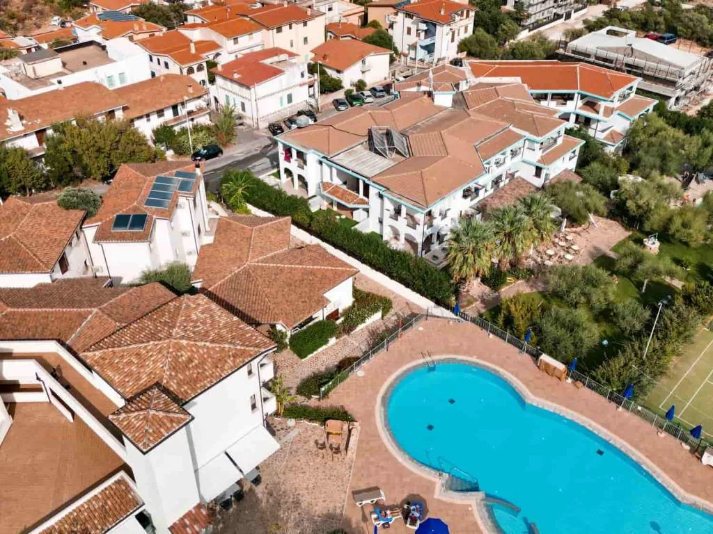 Vista aerea del resort con tetti in coppi, giardini e piscina