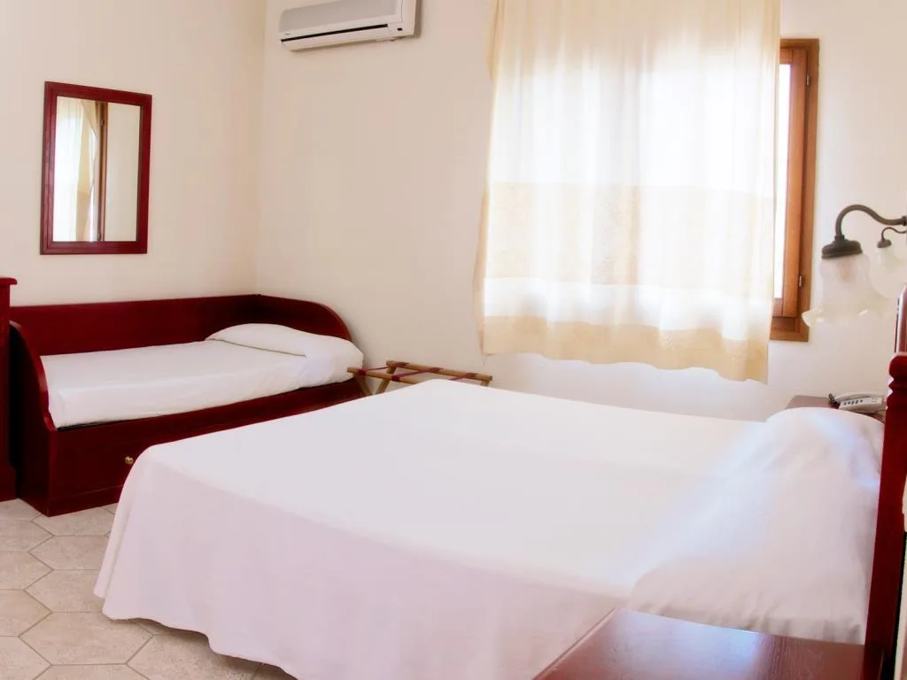 Camera luminosa con letto matrimoniale, divanetto letto rosso e aria condizionata