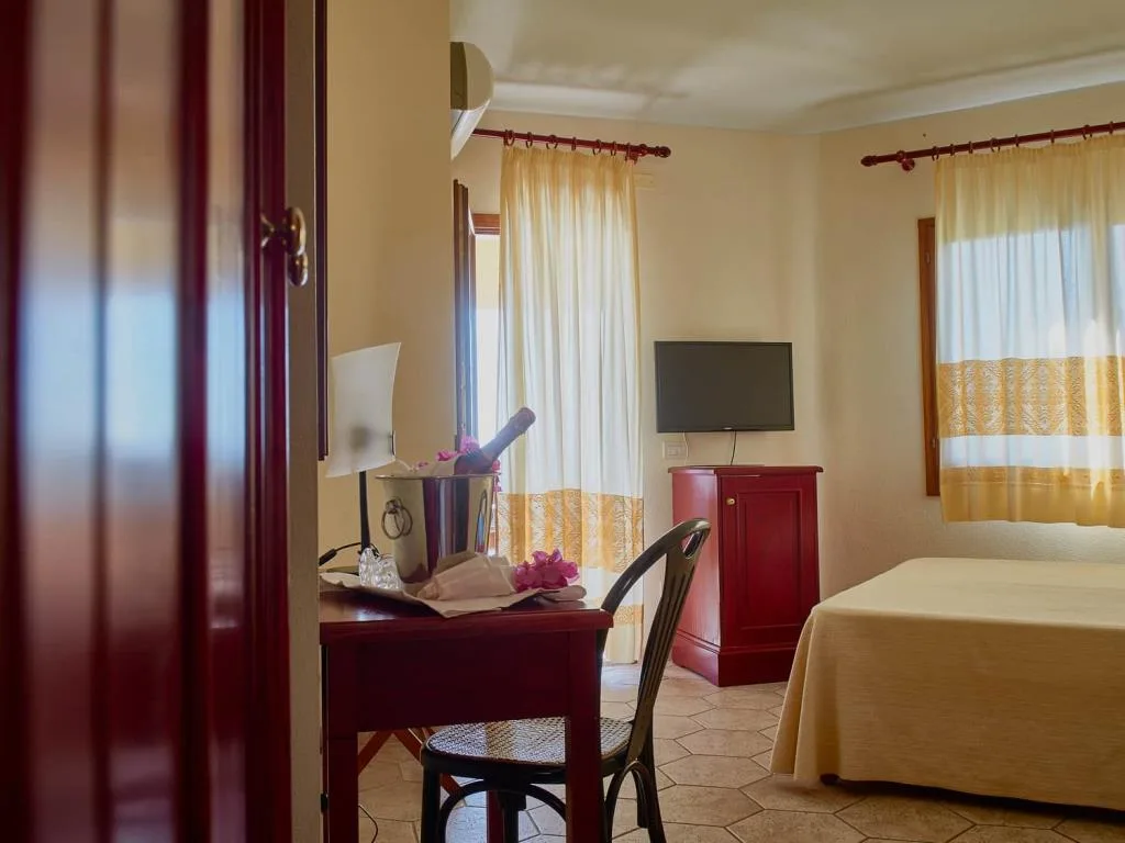 Camera con scrivania, secchiello per champagne e fiori, TV e letto matrimoniale