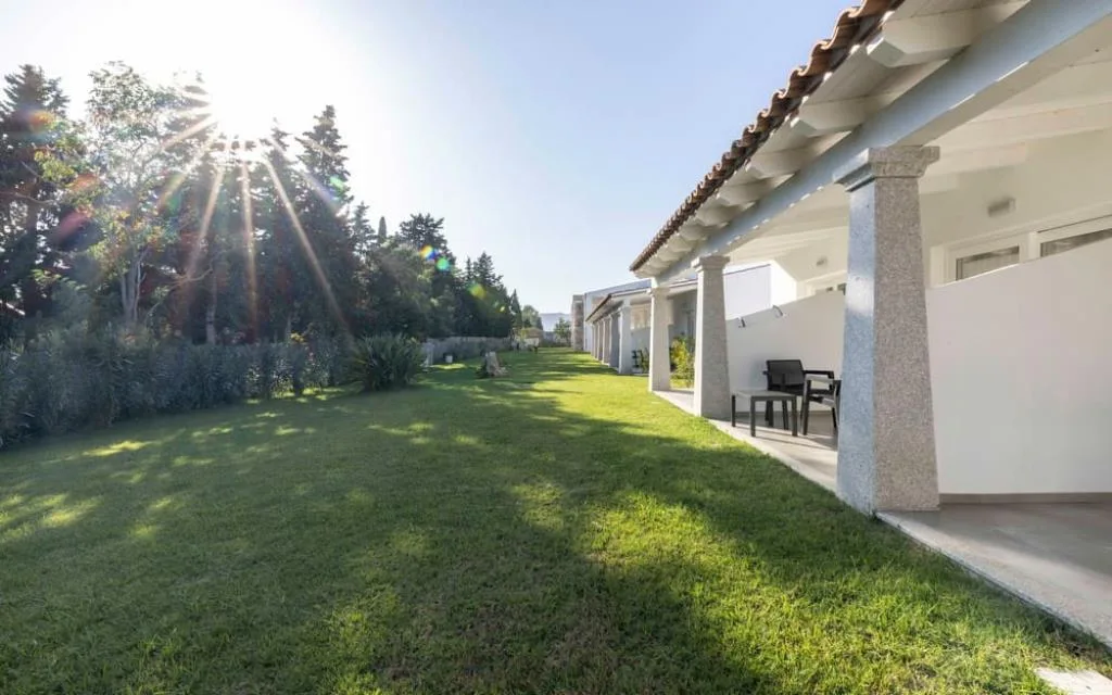 Esterno delle camere con portico, colonne e giardino curato