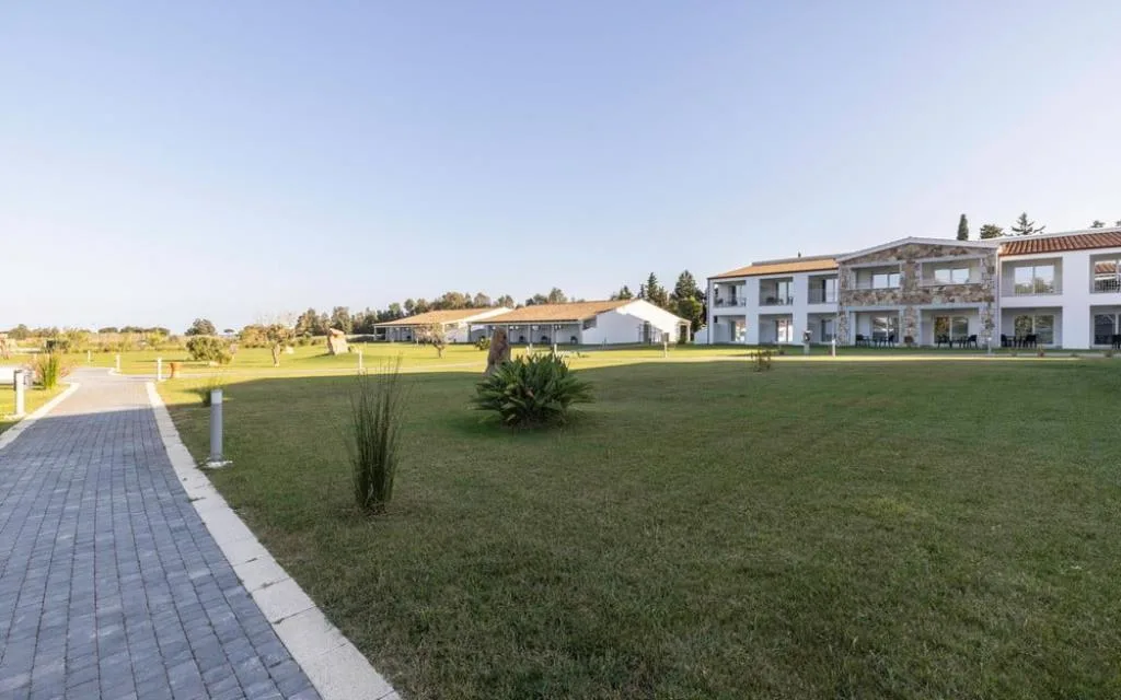 Veduta del resort con edifici in pietra e ampio prato verde